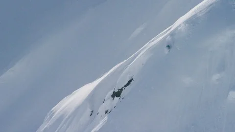 Elite skier speeding down a remote powder covered mountain slope Stock Footage 113250631