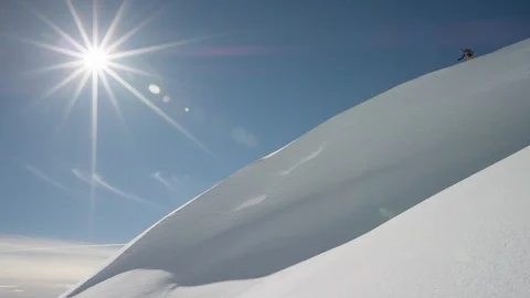 Elite skier speeding down a remote powder covered mountain slope Video stock 113250987