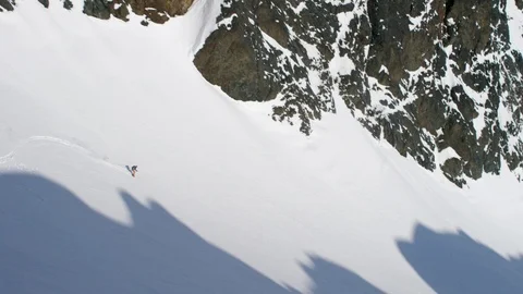 Elite skier speeding down a remote powder covered mountain slope Stock Footage 113251955