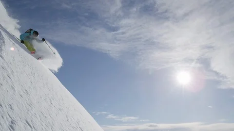Elite skier spraying powder while cruising down a remote mountain Stock Footage 113258080