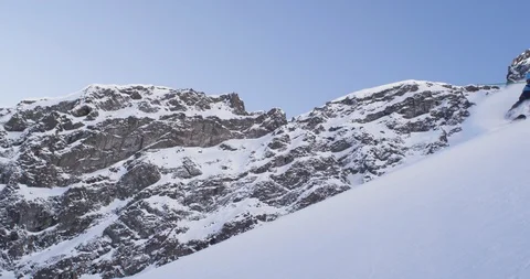 Elite skier spraying snow as he cruises down remote mountainside Stock Footage 111995004