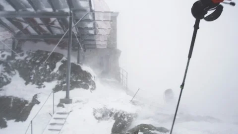 Elite skier at the summit of a mountain during a blizzard Stock Footage 113218494