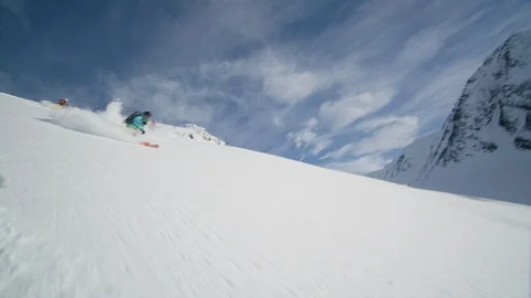 Elite skiers cruising down a remote mountain Stock Footage 113258484