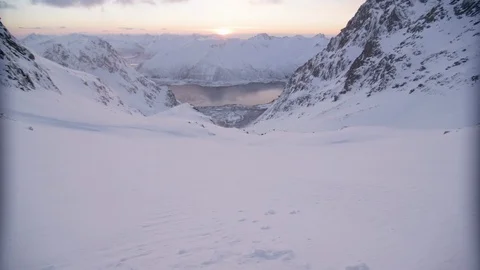 Elite skiers speeding between two mountain peaks at sunset Stock Footage 113225255