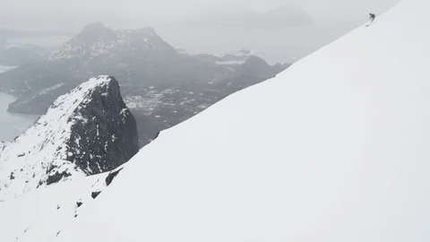 Elite skiers speeding down remote mountain slope in a snow storm Stock Footage 113227441