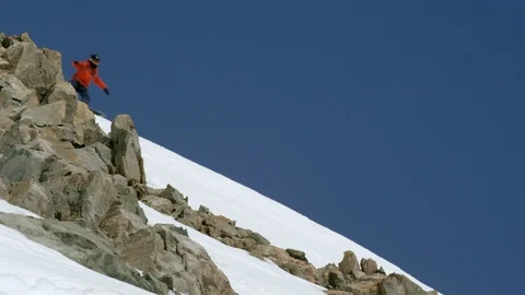 Elite snowboarder cruising down remote mountain on a sunny day Stock Footage 113267030