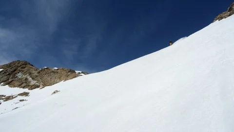Elite snowboarder cruising down remote mountain on a sunny day Stock Footage 113267115