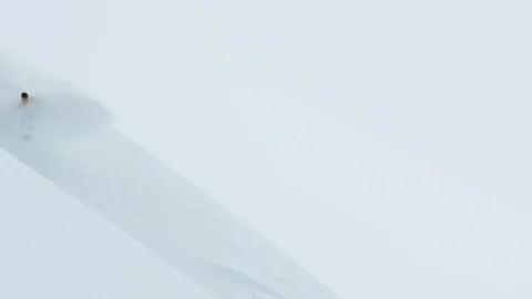 Elite snowboarder cruising down the slopes of a snowy mountain Stock Footage 113261255