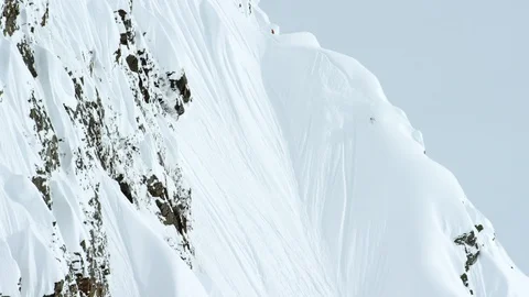 Elite snowboarder cruising down the slopes of a snowy mountain Stock Footage 113261390