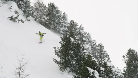 Elite snowboarder cutting through fresh powder on a woodsy slope Stock Footage 113237304