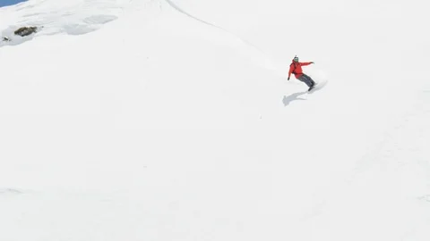Elite snowboarder cutting through fresh powder on a remote mountain Stock Footage 113254729