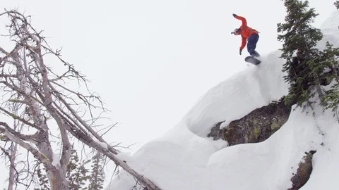 Elite snowboarder jumping down mountain and wiping out Stock Footage 116745167