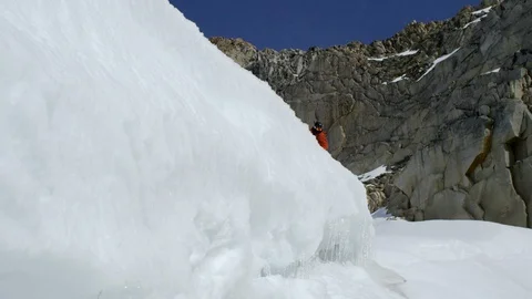 Elite snowboarder jumping off of an icy ledge Stock Footage 113267064