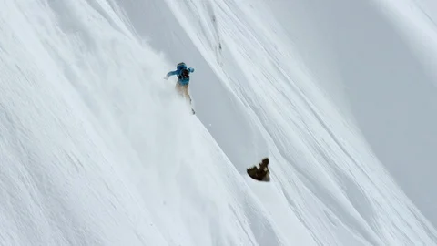 Elite snowboarder performing tricks on a remote mountain Stock Footage 113261342