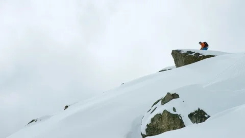 Elite snowboarder performing tricks on a remote mountain Video stock 113261477
