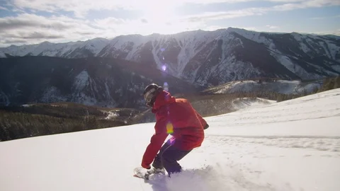 Elite snowboarder performing tricks while gliding down a remote mountain Video stock 113203640
