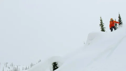Elite snowboarder performs Indy grab stunt while snowboarding on mountain slope Stock Footage 116788424