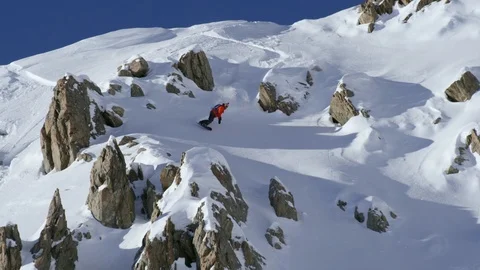 Elite snowboarder sliding down snow covered mountain Stock Footage 116748428