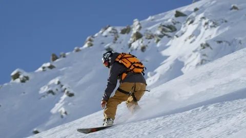 Elite snowboarder sliding down snow covered mountain on sunny day Video stock 116748830