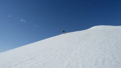 Elite snowboarder speeding down mountain slope towards icy water Stock Footage 113266802
