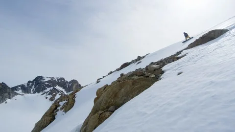 Elite snowboarder speeding down mountain ridge Stock Footage 113268737