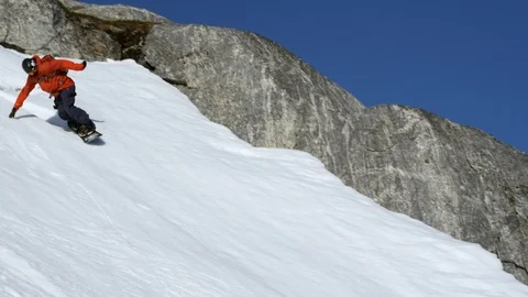 Elite snowboarder spraying snow on a remote mountain Stock Footage 113267223
