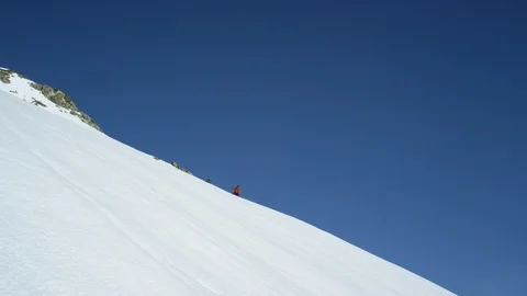 Elite snowboarders speeding down mountain slope towards icy water Stock Footage 113266619