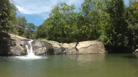 Ella, Sri Lanka - march 5th 2025: man jumps off rock into hidden waterfall pool Video stock 307862440