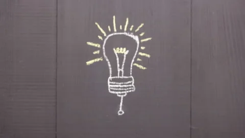 The ellectric light bulb drawn on the chalk board lights up Stock Footage 137626361