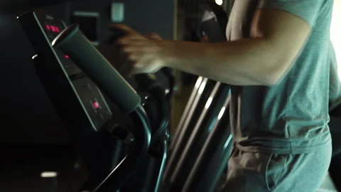 On an elliptical training machine in a gym young people are training. Stock Footage 90363447