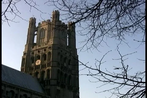 Ely Cathedral Tower as seen through trees against a blue sky Stock Footage 992271