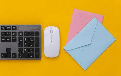Email. PC keyboard and envelopes on yellow background. Stock Photos