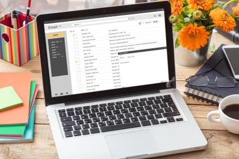 Emails list on a computer screen on a wooden office desk Stock Photos