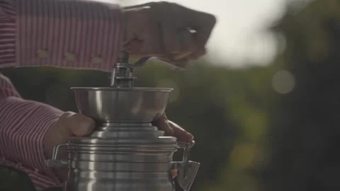 Emale hand grinding roasted coffee beans in rustic manual grinder Stock Footage 164094120