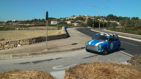 Emanuel Demis Abela 1978 Austin Mini Saloon 13 slow‑motion run on sweeping Stock Footage 324935341