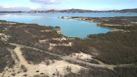 Embalse de la Pedrera, with a cyclist riding on the road along the lake Stock Footage 230923265