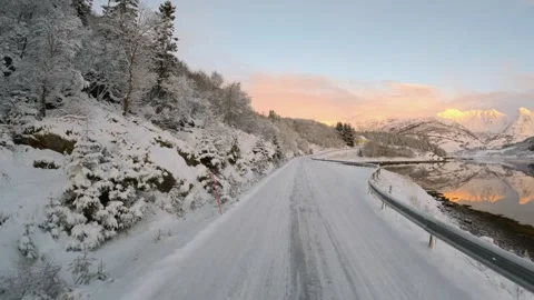 Embark on a winter road trip through Lofoten, Norway, where the snowy terrain Stock Footage 258695569