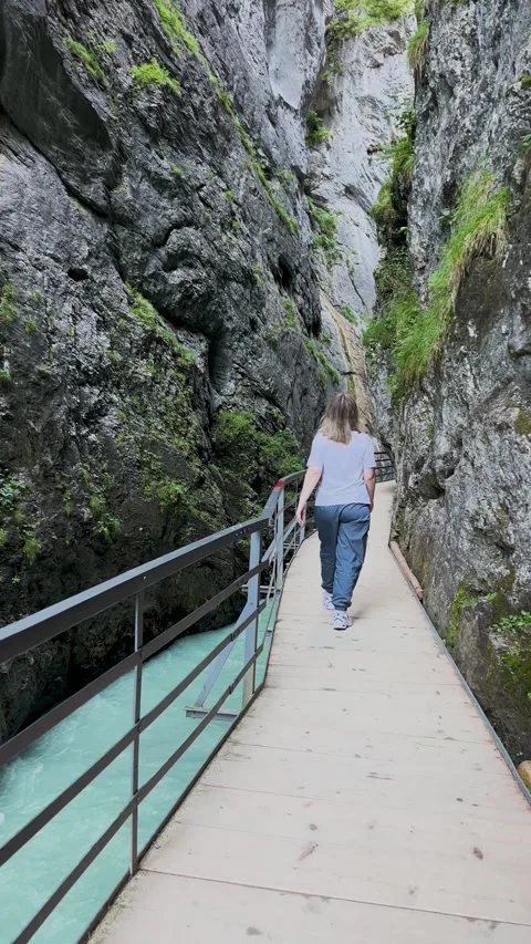 Embarking on a journey through a tranquil canyon pathway embraced by natures Stock Footage 304783453