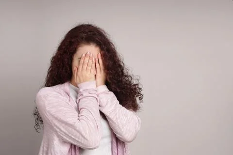 Embarrassed young woman hiding her face Stock Photos
