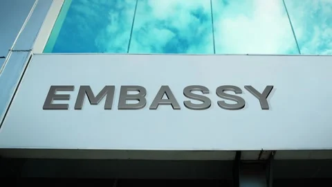 Embassy Sign on Modern Building with Cloud Reflection on Windows Glass Stock Footage 303557743