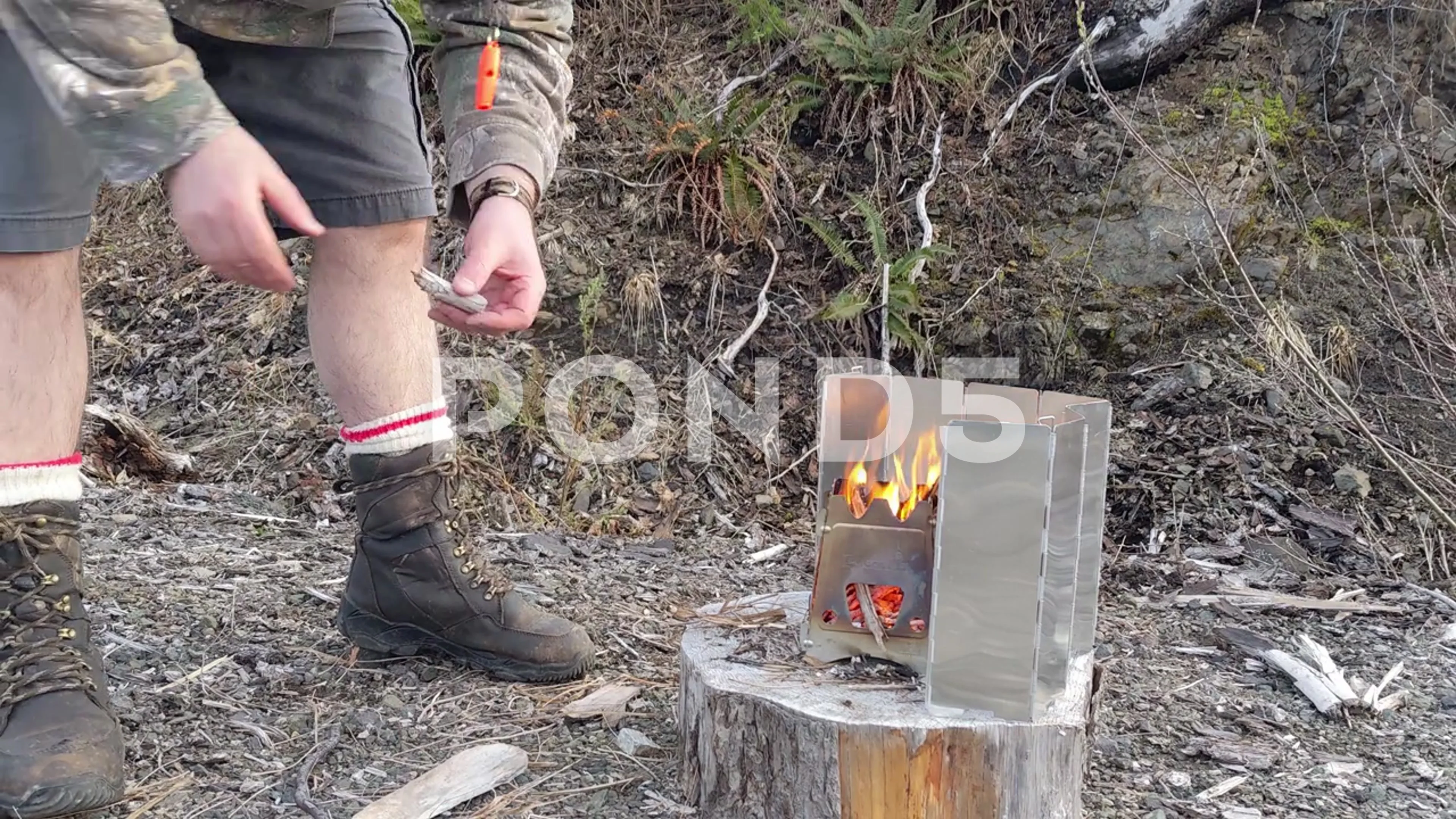 Emberlit Stove feeding wood for flames | Stock Video | Pond5