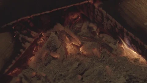 Embers glowing red hot at base of wood fire in fireplace. Stock Footage 99793316