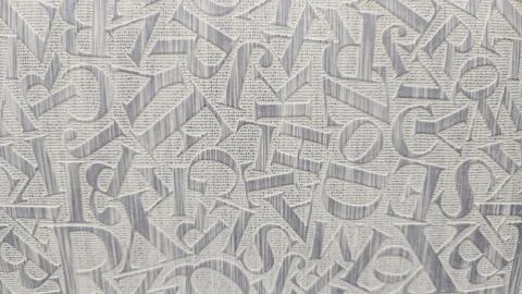  Embossed alphabet pattern on woven fabric background with overlapping seri Stock Photos