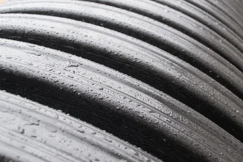Embossed large pipe outside in the rain. Water droplets on the surface of the Stock Photos