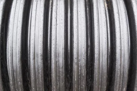 Embossed large pipe outside in the rain. Water droplets on the surface of the Stock Photos