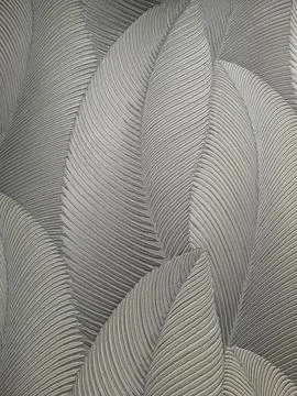 Embossed leaves create a silver and grey wallpaper design with metallic shi.. Stock Photos