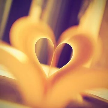 Embossed pages of book folded to make heart Stock Photos