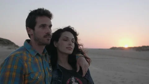 Embraced couple looking into the distance on the beach Stock Footage 131153380