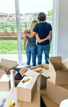 Embraced couple looking through the window Stock Photos