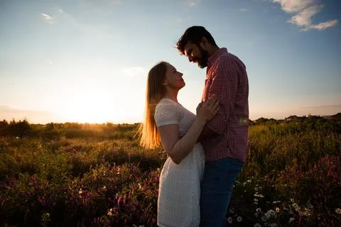 Embracing couple in rays of setting sun Stock Photos